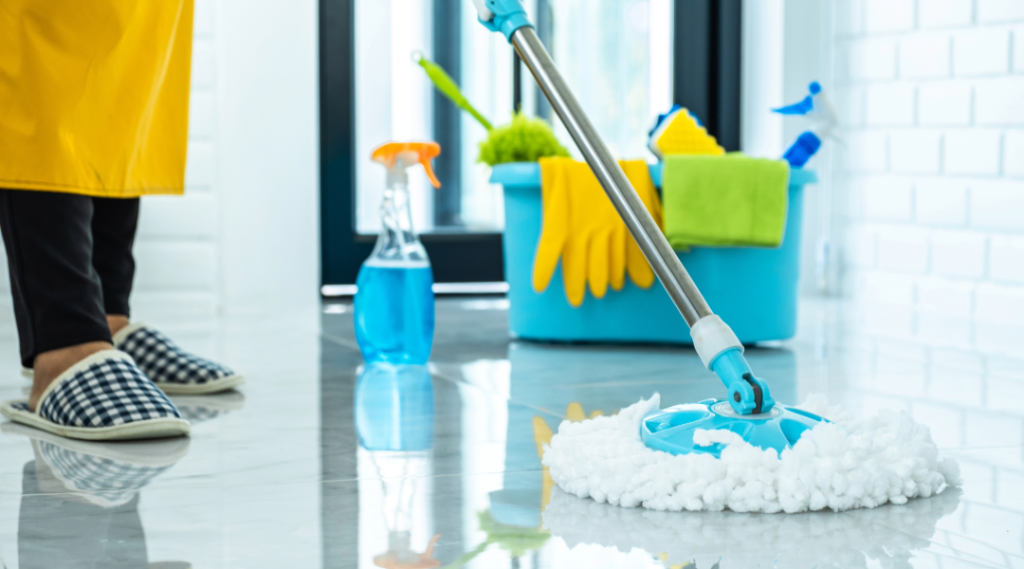 Professional cleaning supplies with a person wiping a glass window — AllPro Clean residential and commercial services